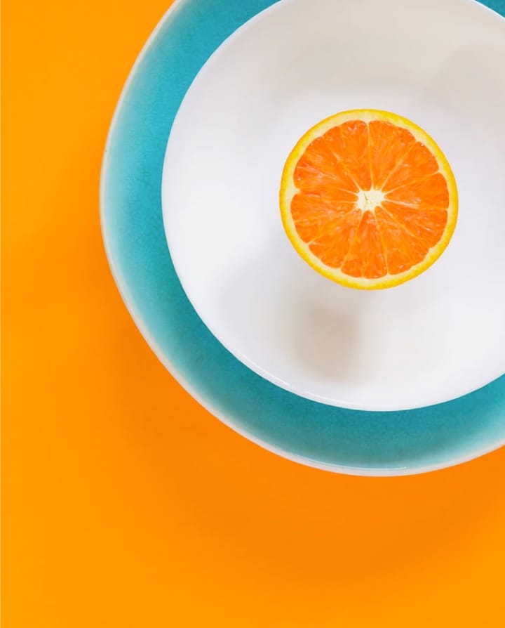 Image of Orange Cut In Half Laying On Plate