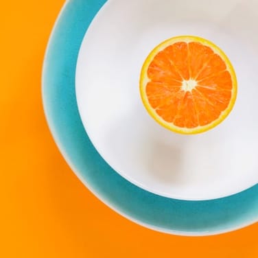 Image of Orange Cut In Half Laying On Plate